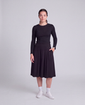 A woman modeling a black modest knee length skirt and side pockets and wide waist band- Flex skirt