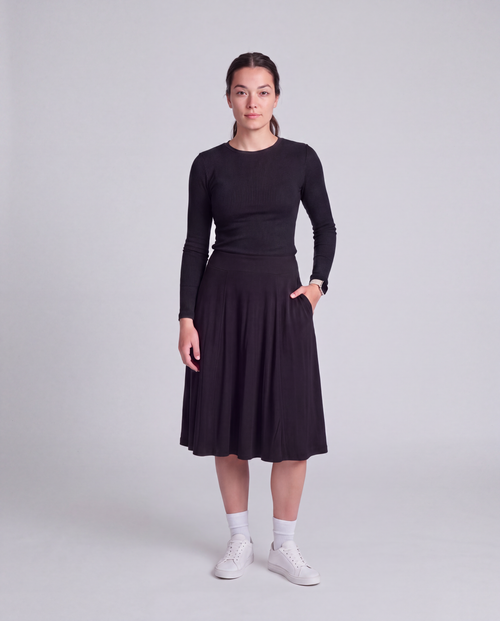 A woman modeling a black modest knee length skirt and side pockets and wide waist band- Flex skirt